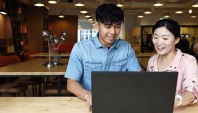 male student at laptop with teacher