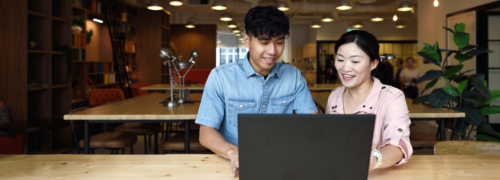 male student at laptop with teacher