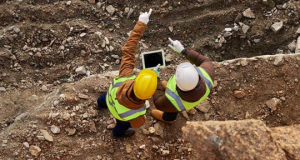 Photo of two male workers pointing outward on a construction site